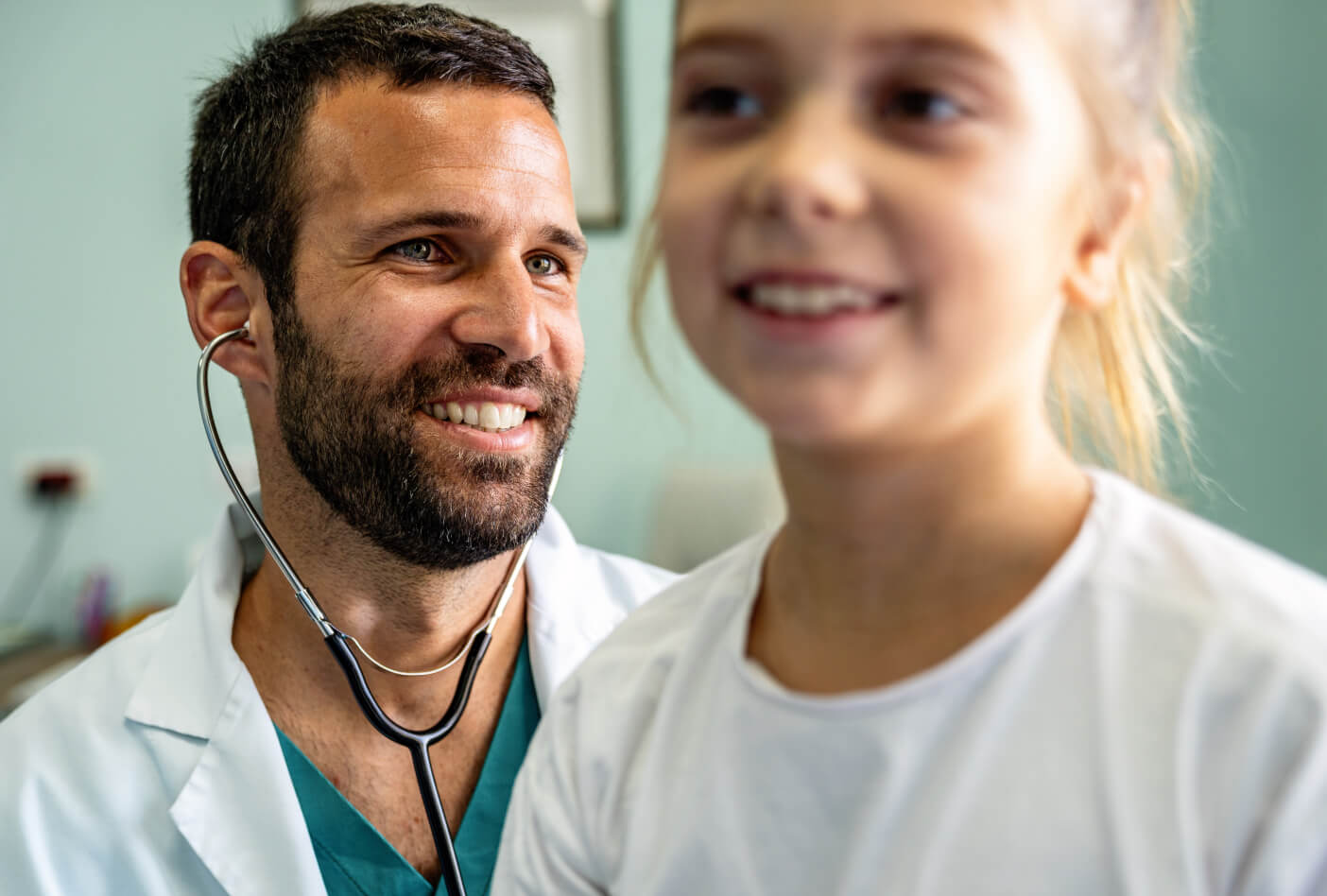 A smiling doctor attends to a young patient