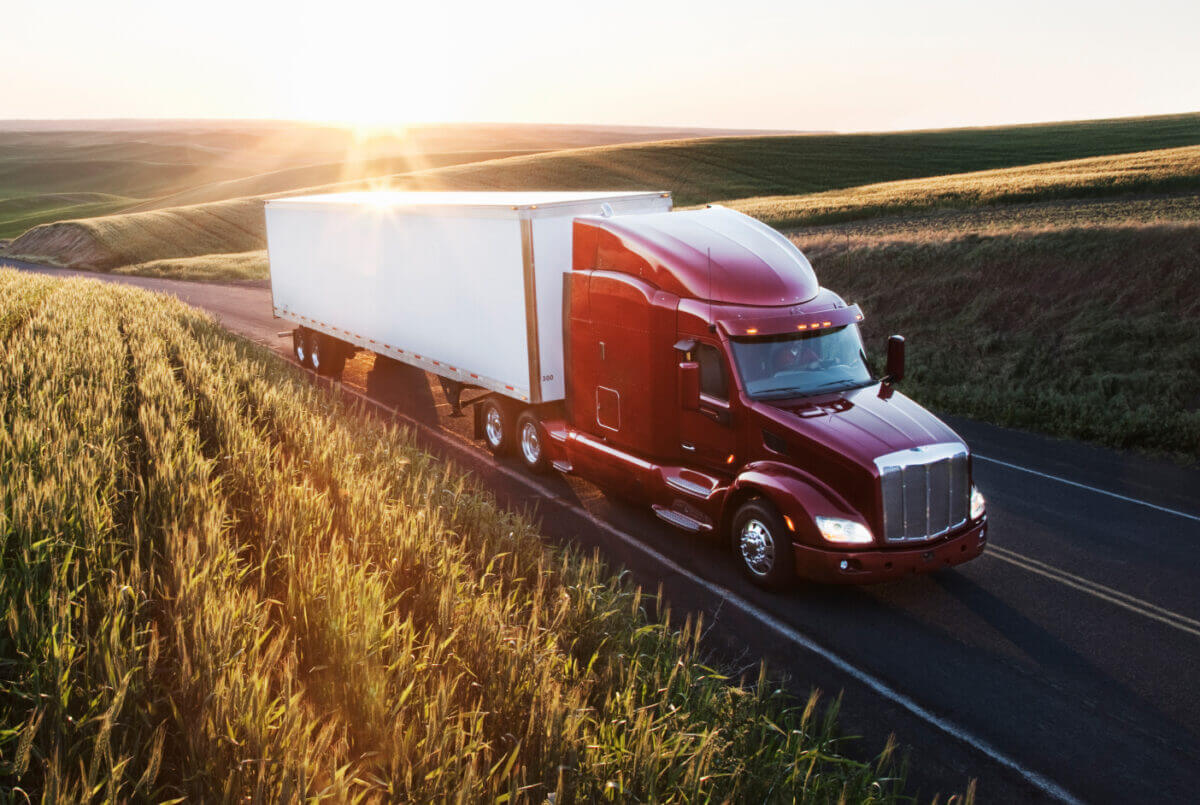 Commercial truck driving alongside wheat fields