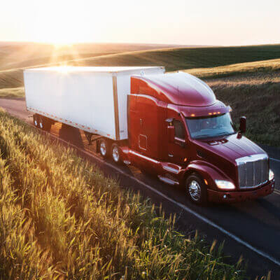 Commercial truck driving alongside wheat fields