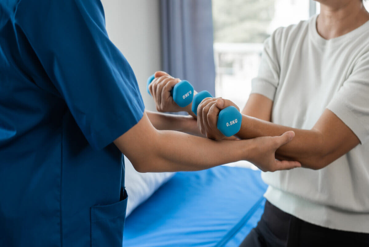 Physical therapy nurse helps a patient with some weights