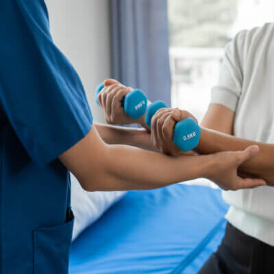 Physical therapy nurse helps a patient with some weights